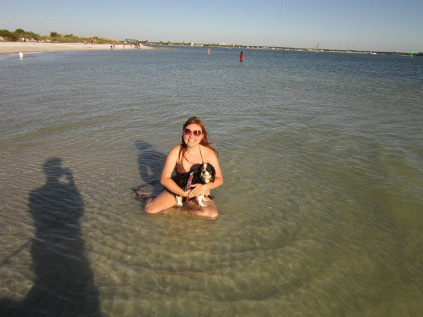 Woman in the ocean water with her dog.