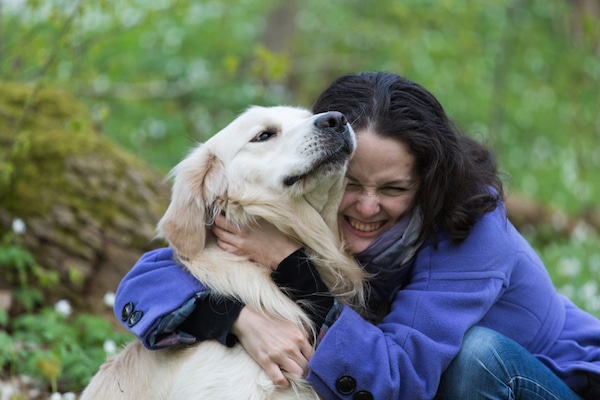 Dog not enjoying a hug by Shutterstock.