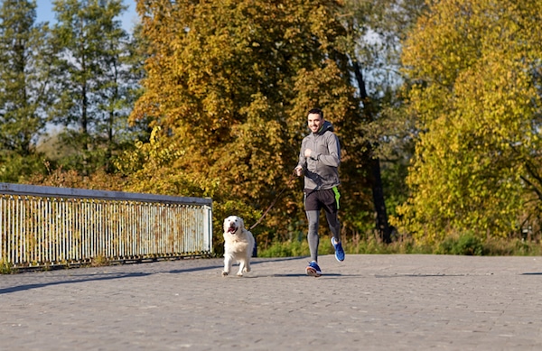 Man running with dog by Shutterstock.