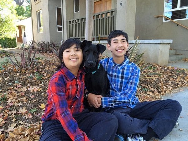 Coco a lab mix hangs out with her two human brothers whose family was considered unfit by one rescue group. (Photo by Annmarie Levitt.)