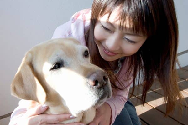 A woman hugging a dog. 