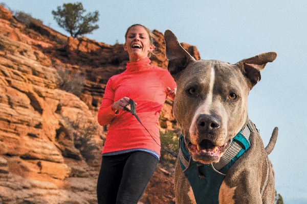 Woman hiking and running with her dog. 