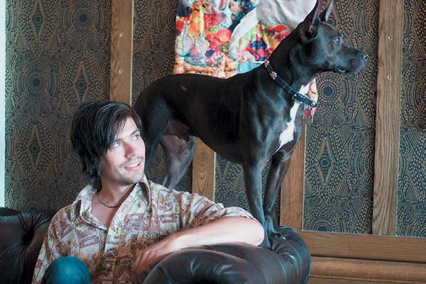 There’s no surprise that dogs and art abound at the Old No. 77 in New Orleans. Pictured with a canine friend is the 2016 artist in residence TJ Kiser.