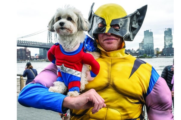 Evan Harding carries his dog Bella as they both wear super hero costumes during the 28th Annual Tompkins Square Halloween dog parade in New York city. Credit: Enrique Shore/Alamy Live News