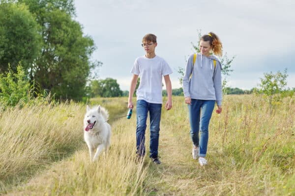 teens walking with dog