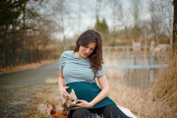 Pregnant woman sitting with a cute dog