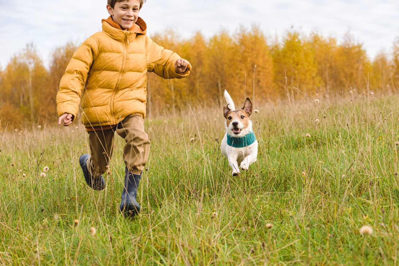 Happy smiling kid and his dog running