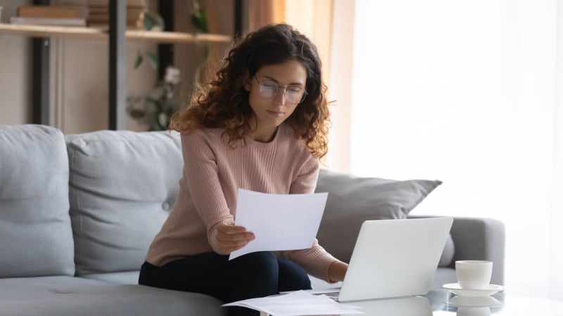 woman sitting on couch reading the paper