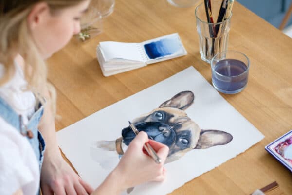 woman drawing or painting a french bulldog