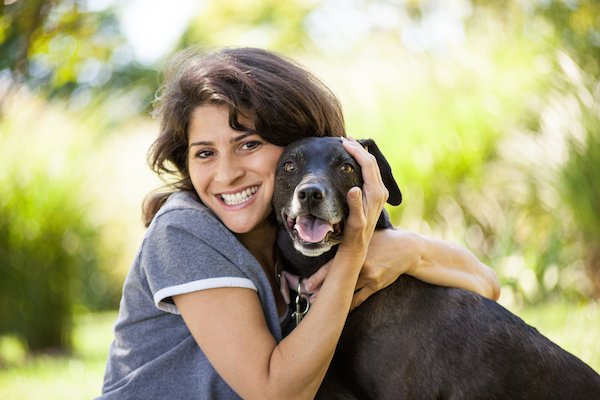 Make sure your pooch is left in good hands.] (Woman with dog by Shutterstock)