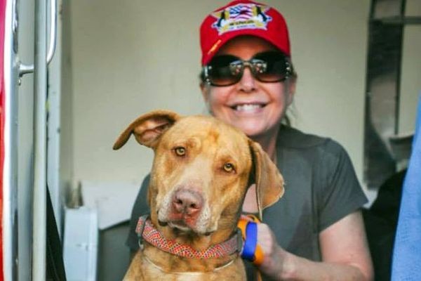 Pilot Cindy Smith poses with one of the dogs saved from a Los Angeles county shelter. Photo credit Ric Browde.