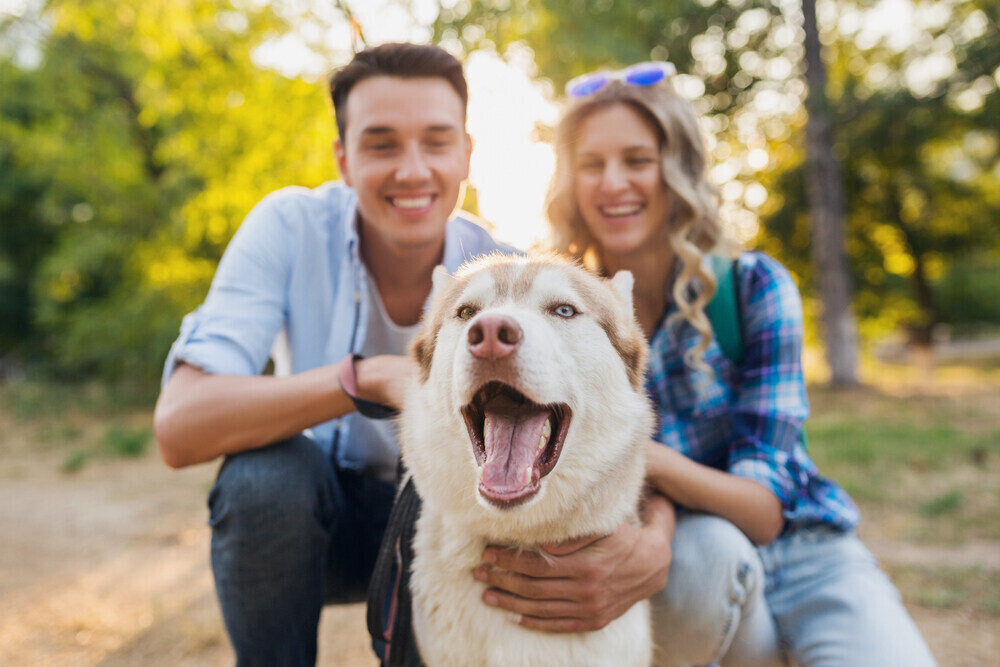 a couple with their pet dog outdoors