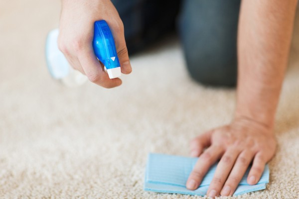 Man cleaning carpet by Shutterstock.