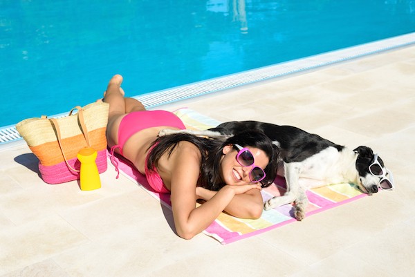 Woman and dog poolside by Shutterstock.
