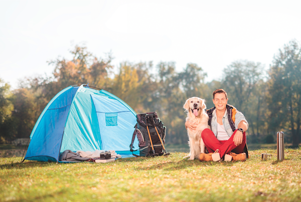 Man and dog camping by Shutterstock.
