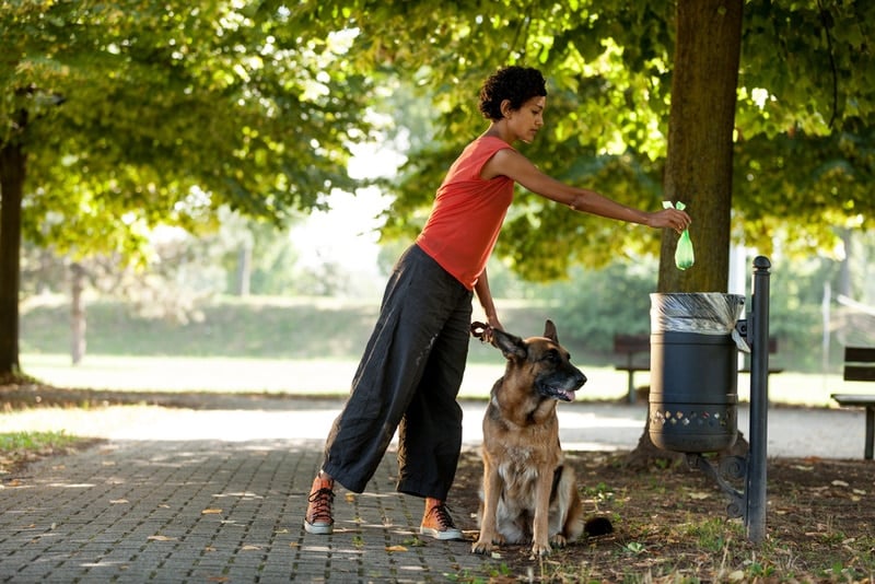 woman throwing dog poop