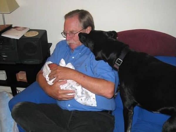 Riggins' sneaks a kiss from his Grandpa while holding baby Logan. (Photo by Wendy Newell)