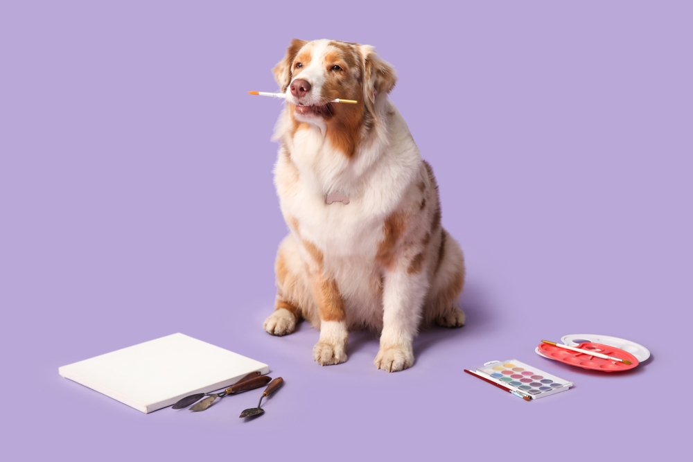 Cute dog near art supplies on lilac background