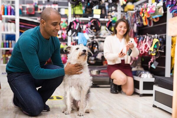 man hugging dog while shopping in pet store