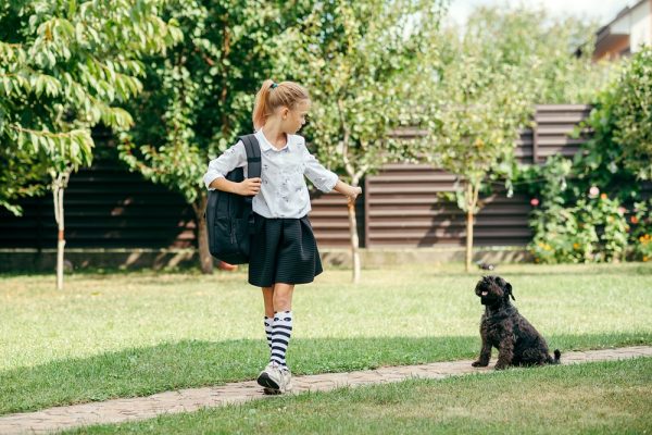 Girl going to school saying bye to her dog