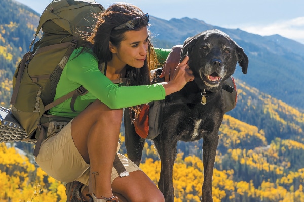 A woman hiking with her dog.