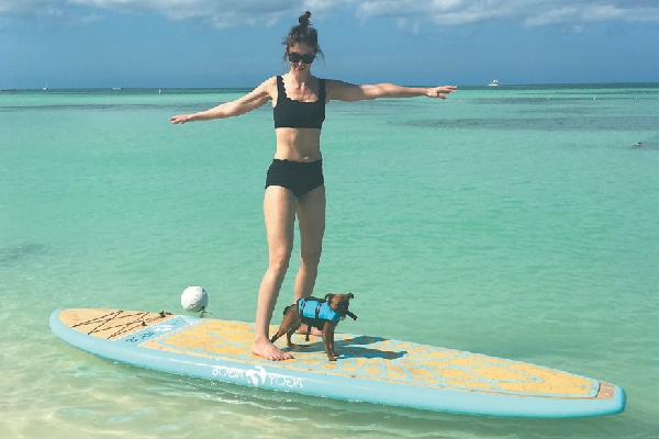 Sigrid and Sprout try their hand/paw at paddleboarding, one of the many outdoor activities available.