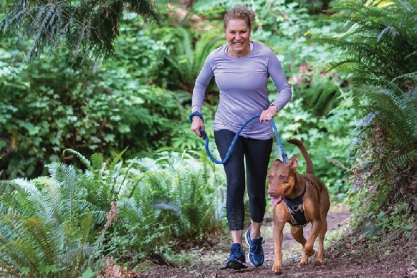 A woman and a dog out for a walk.