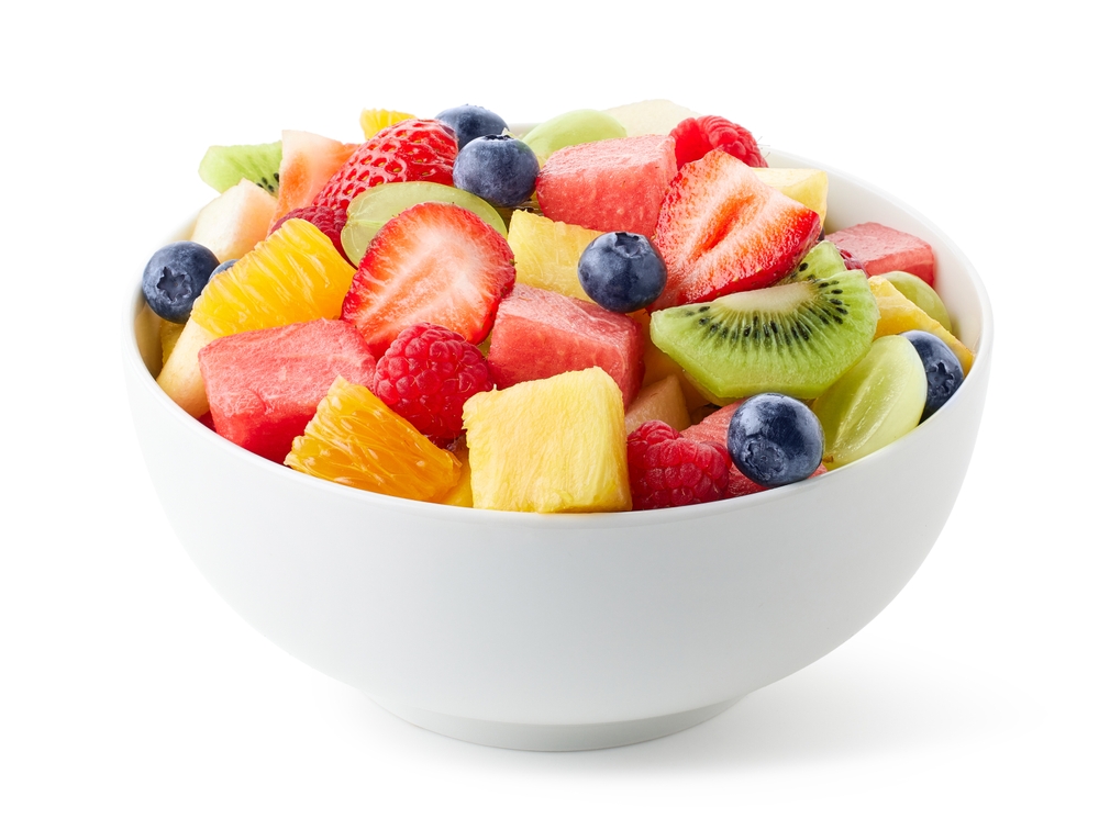 White bowl of fresh fruit salad isolated on white background. Healthy summer meal