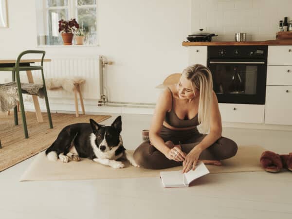 Woman and her dog on a yoga mat