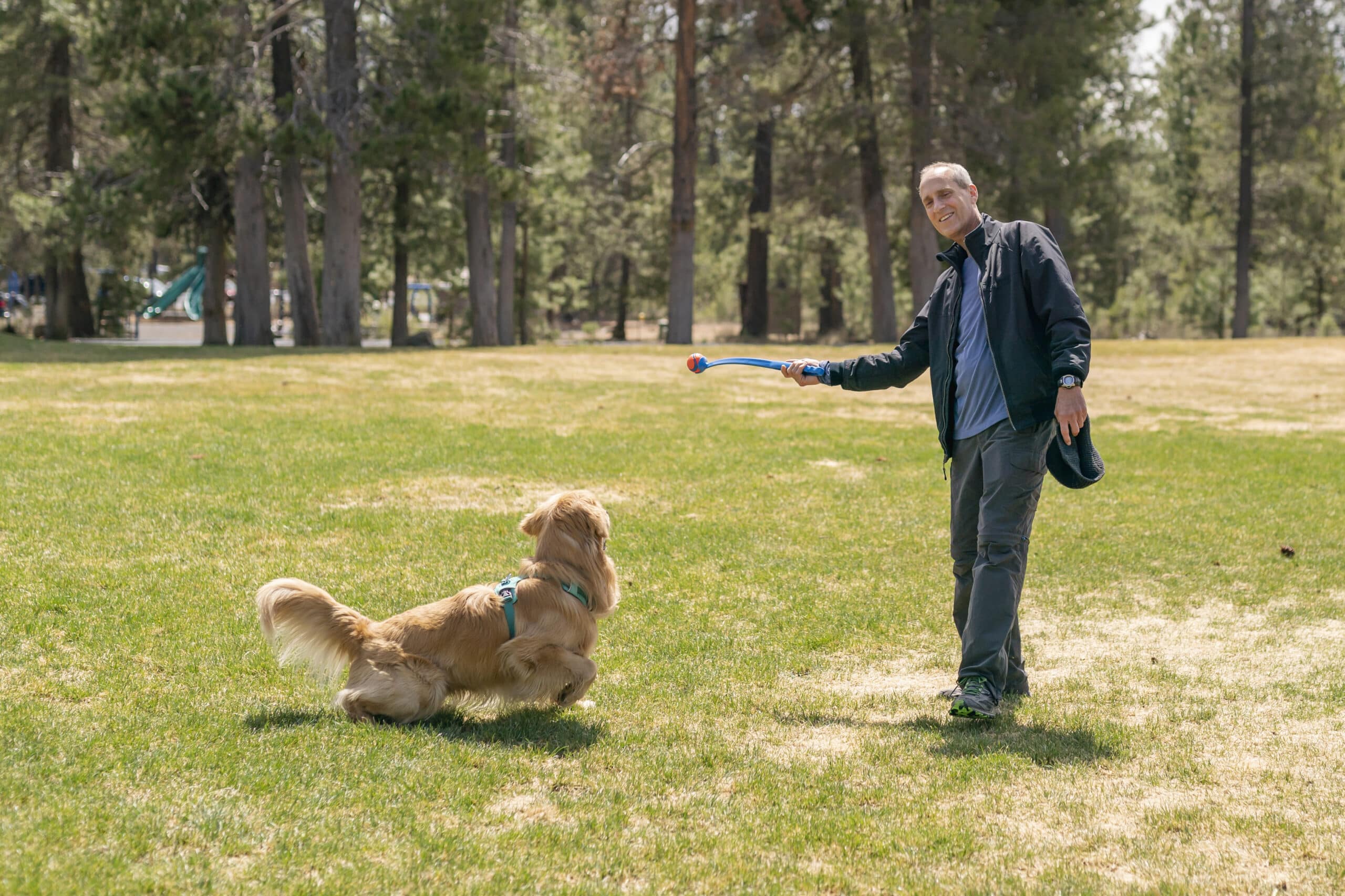 Senior man playing fetch with his golden retriever
