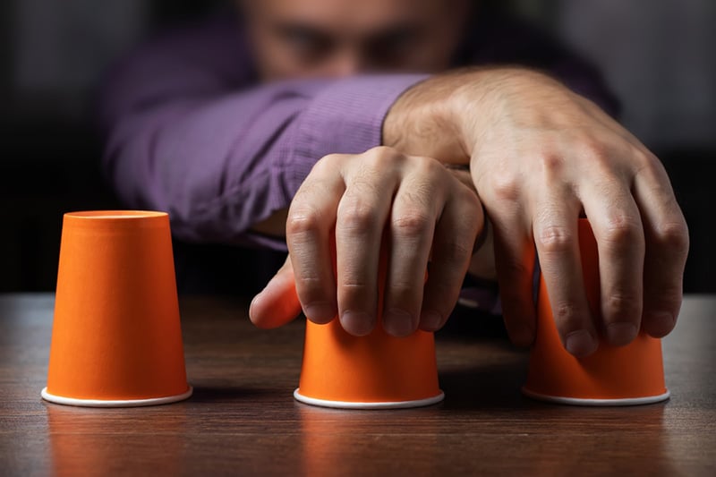 Man shows shell game of thimbles