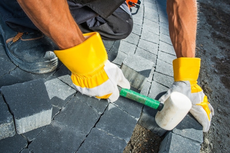 man paving garden path