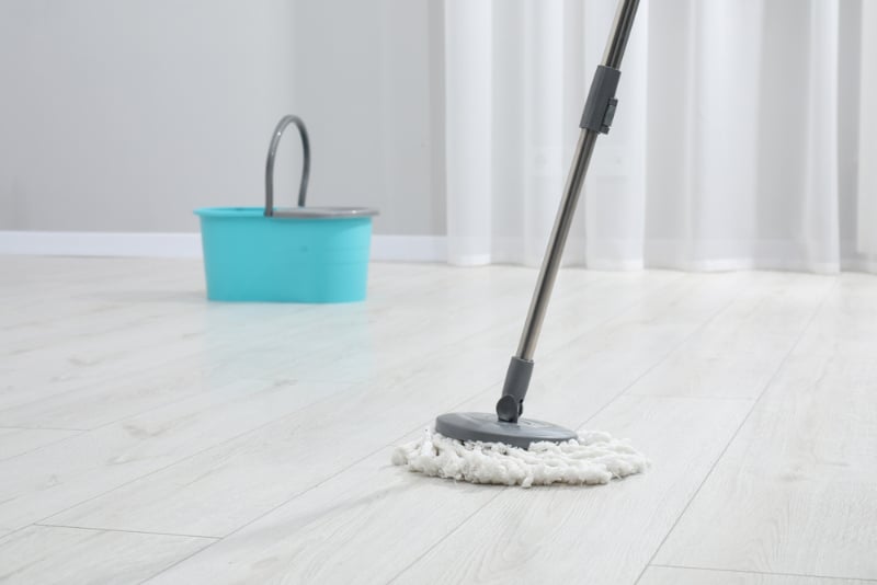 Cleaning dirty wooden floor with mop