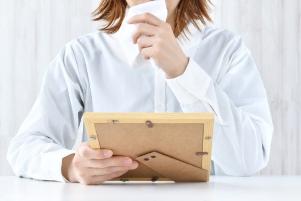 Woman crying while looking at photograph frame