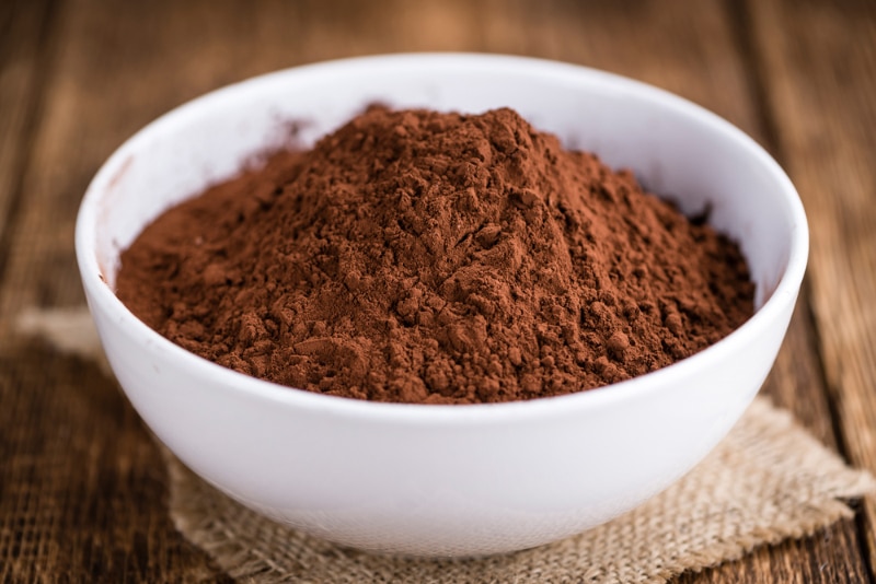 a bowl of cocoa powder on wooden table