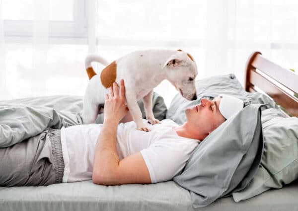 a man waking up to his dog standing on him