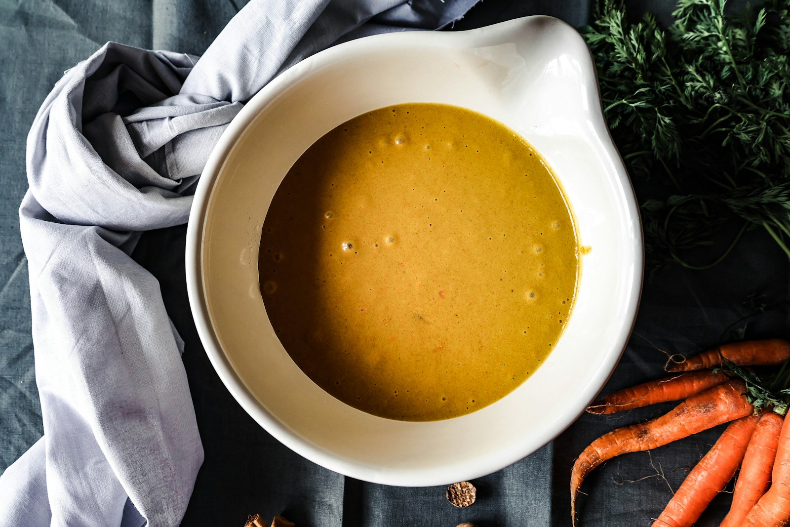 a bowl of soup with carrots and parsley