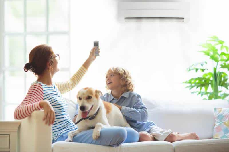 mom with child and pet dog, turning on the aircon during hot weather
