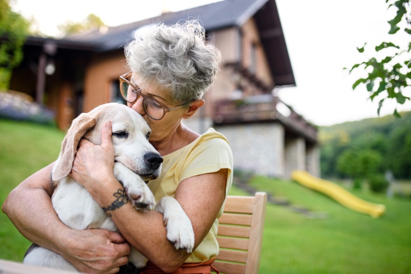 senior woman hugging her dog outdoor