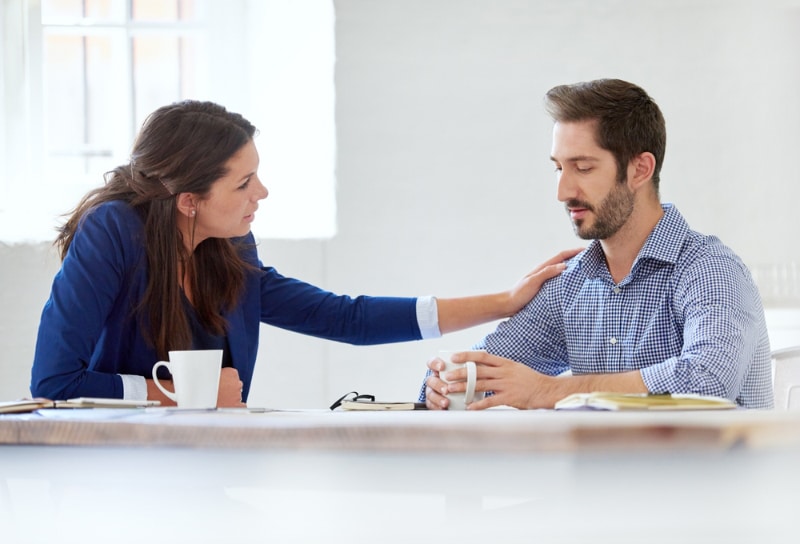 woman consoling his colleague at work