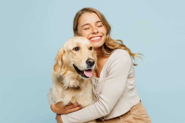 woman cuddling with her pet golden retriever