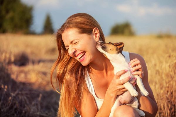 Dog licking woman's ear