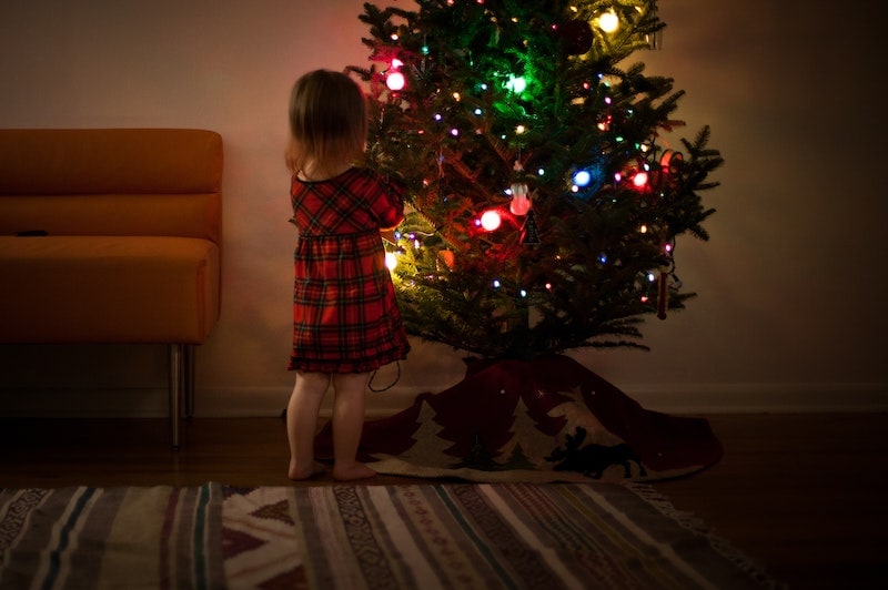 Girl standing beside a christmas tree