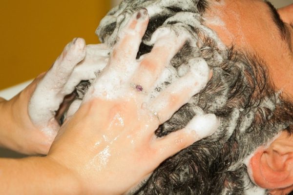 Man getting shampoo treatment from hairdresser