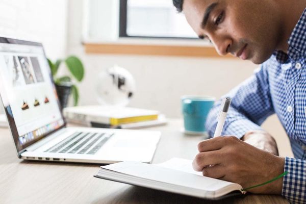 Man writing and doing research