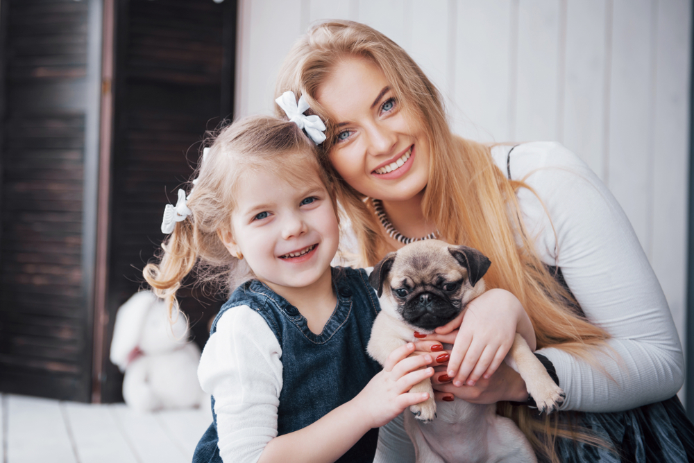 Pug puppy with a girl and a woman (family)