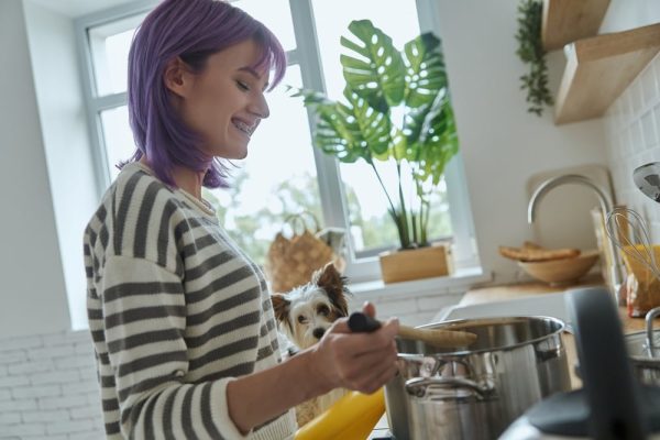 Woman Coocking In A Kitchen Beside a Dog