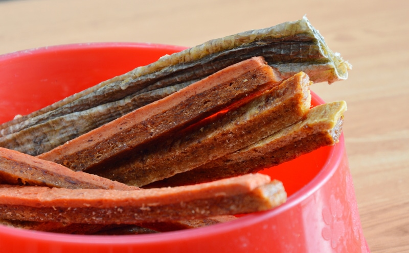 chicken jerky treats on red bowl