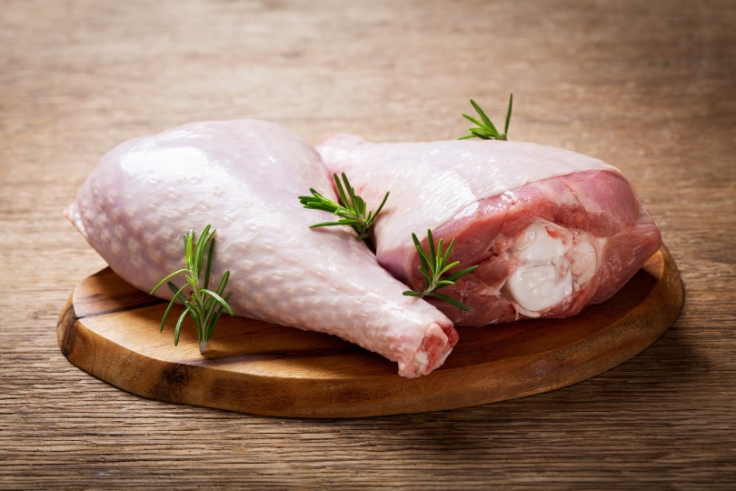 fresh turkey legs on wooden board