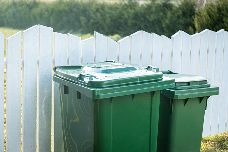 garbage can behind fence